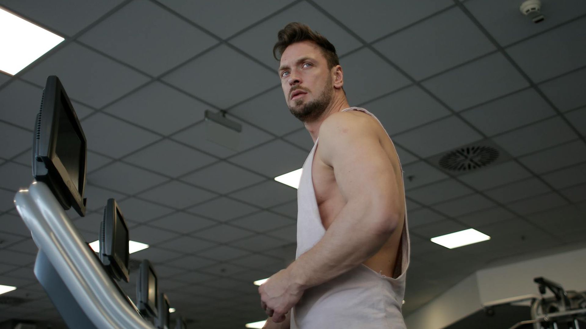 A focused man performing strength exercises in a gym environment