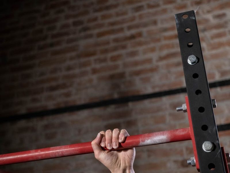 Close up of a man's hands gripping a pull up bar